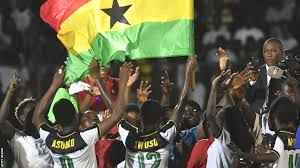 Ghanaian football players celebrating with the national flag.