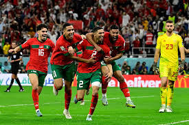 "Soccer players celebrating on the field in red and green jerseys."