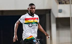 "Soccer player in a white jersey with colorful stripes during a match."