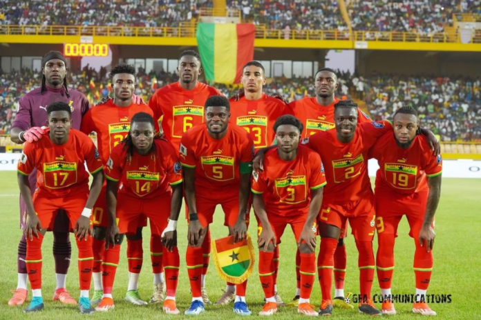 "National soccer team posing for a group photo in red jerseys."