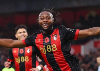 "Soccer player in a red and black jersey celebrating a goal."