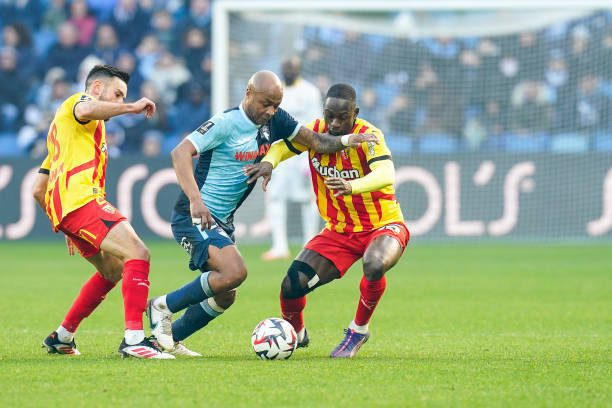 Andre Ayew in action against RC Lens players during a Ligue 1 match.