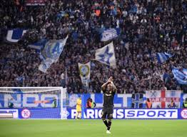 "Andre Ayew applauding fans in a packed stadium."