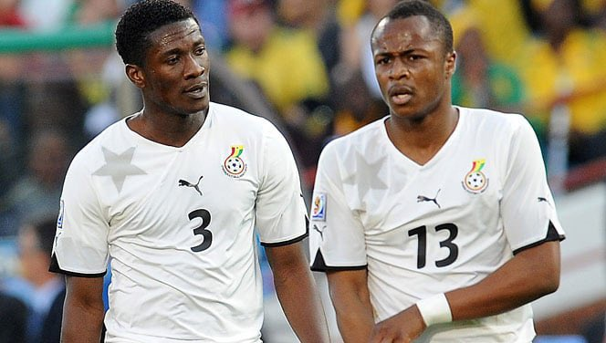 "Two Ghanaian football players in national team jerseys during a match."