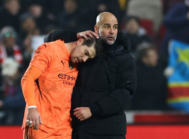 Pep Guardiola consoling a Manchester City player on the sidelines during a match."