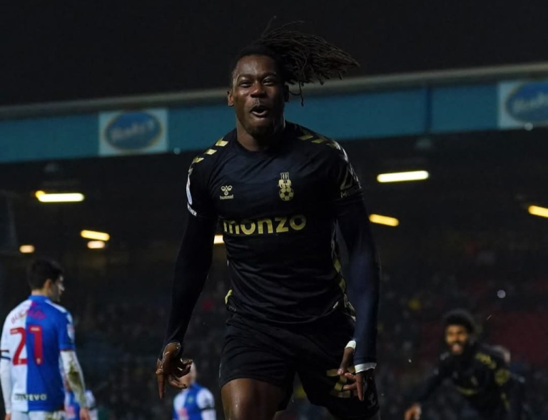 "Football player celebrating after scoring during a night match."