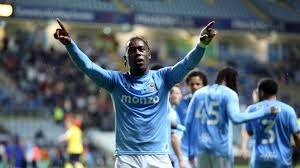 "Football player celebrating with arms raised during a match."