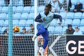 "Football player warming up near the goal net during a practice session."