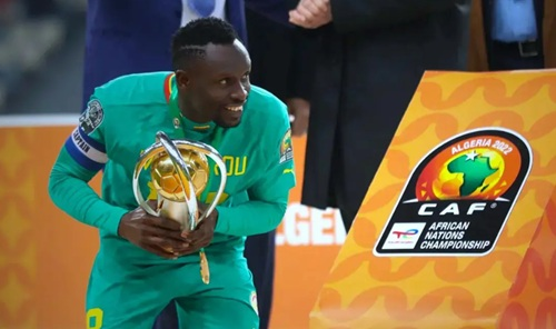"Football player holding a trophy during a CAF event."