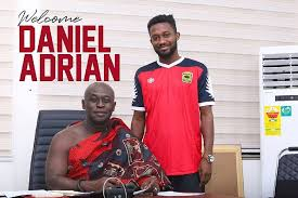 Daniel Adrian Adjetey poses with a traditional elder while wearing an Asante Kotoko jersey during his official unveiling