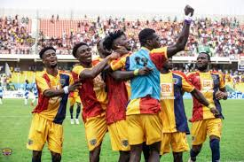 Hearts of Oak players celebrating together on the field after a match victory."