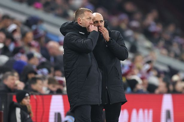 "West Ham United coaches discussing tactics on the sidelines."