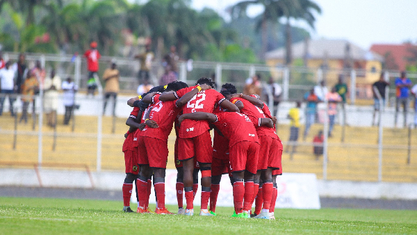 "Asante Kotoko players huddling together before the start of a match."