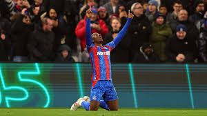  Crystal Palace player celebrating a goal by kneeling and pointing to the sky. 
