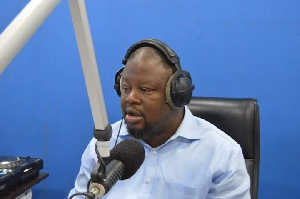 "Radio host speaking into a microphone during a live broadcast."