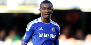 Nigerian footballer in a Chelsea jersey during a match, displaying focus and readiness on the field
