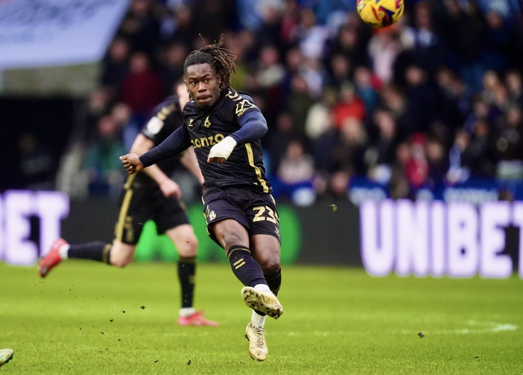 "Soccer player in black and gold kit sprinting during a match."