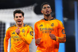 Real Madrid players in orange jerseys celebrating during a match.