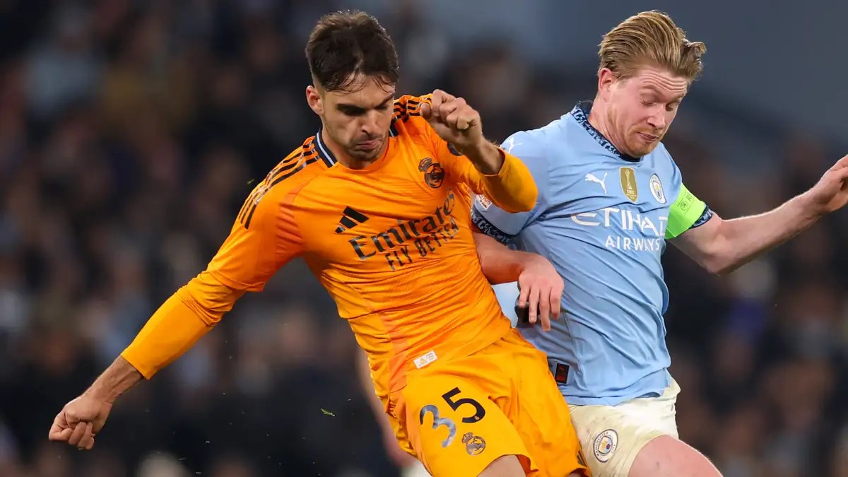 "Real Madrid and Manchester City players battling for the ball during a match."