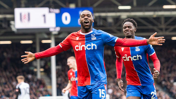 Footballer celebrating a goal in a red and blue jersey.