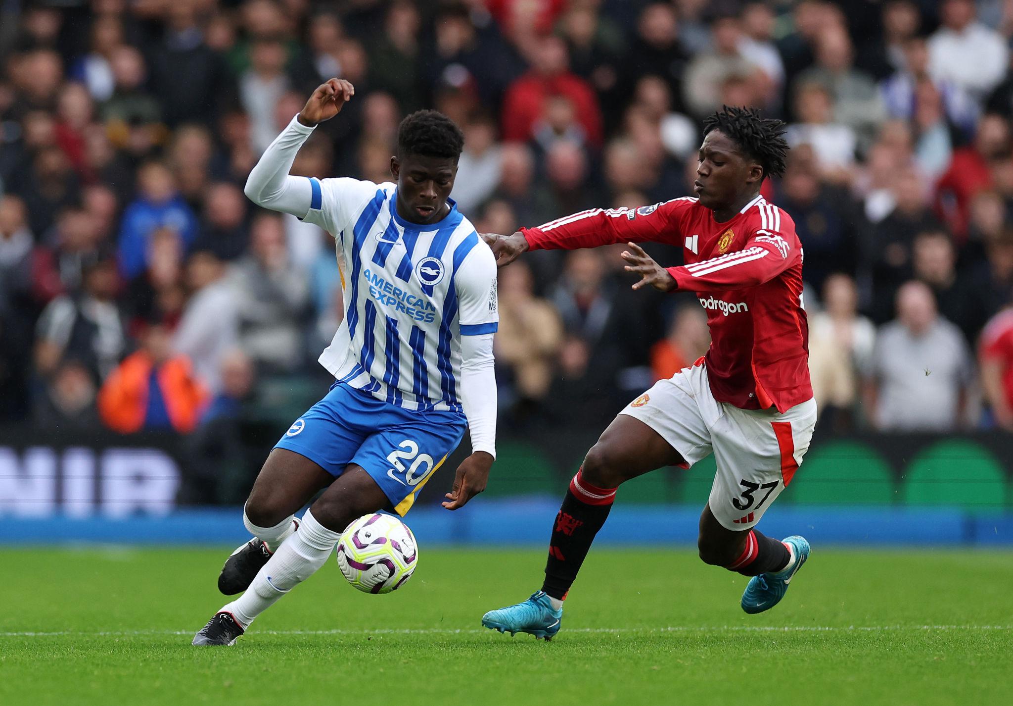 Baleba wa Brighton mwenye jezi ya bluu na nyeupe akidhibiti mpira huku akipambana na Kobbie Mainoo wa Manchester United mwenye jezi nyekundu.