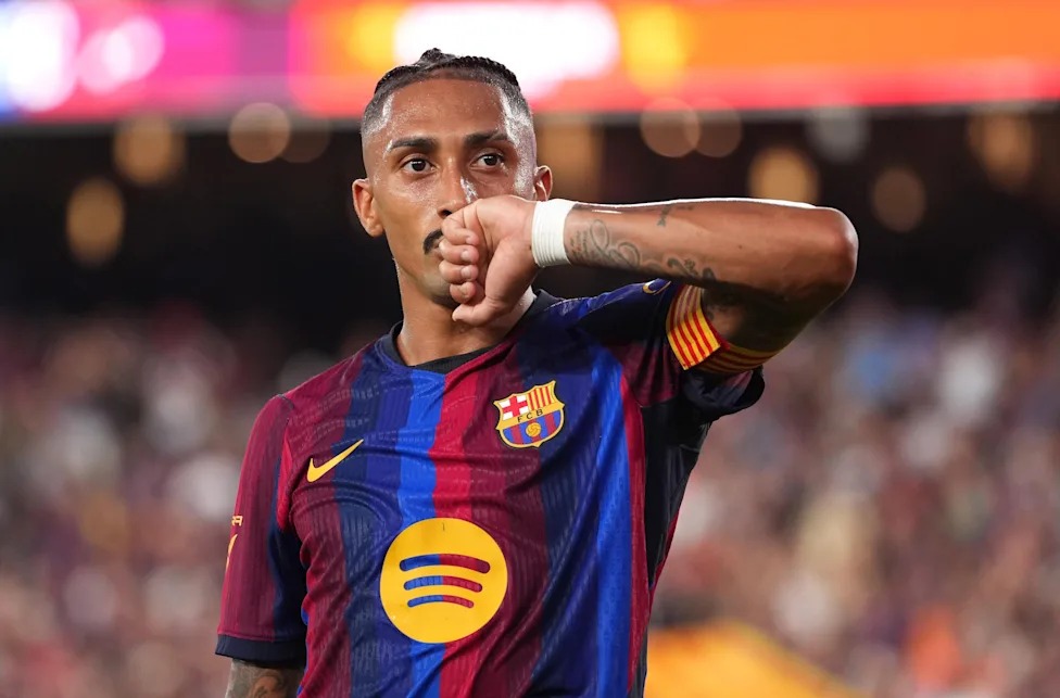 Mchezaji wa Barcelona Raphinha akishangilia goli kwa kubusu mkono wake akiwa amevaa jezi ya nyumbani ya Barcelona.