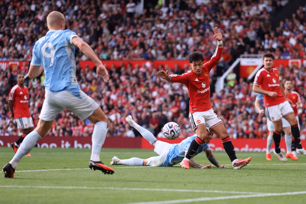 Beki wa Manchester United, Lisandro Martínez, akicheza mpira chini mbele ya mshambuliaji wa Manchester City, Erling Haaland.