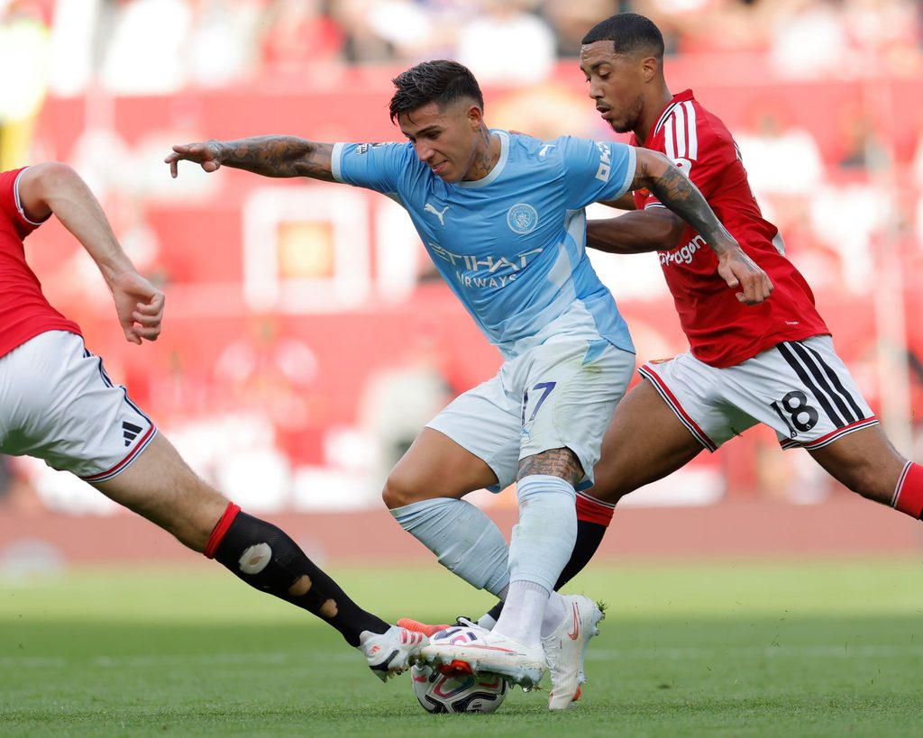 Kiungo wa Manchester City, Enzo Fernández, akipambana kuwania mpira na beki wa Manchester United uwanjani Old Trafford.