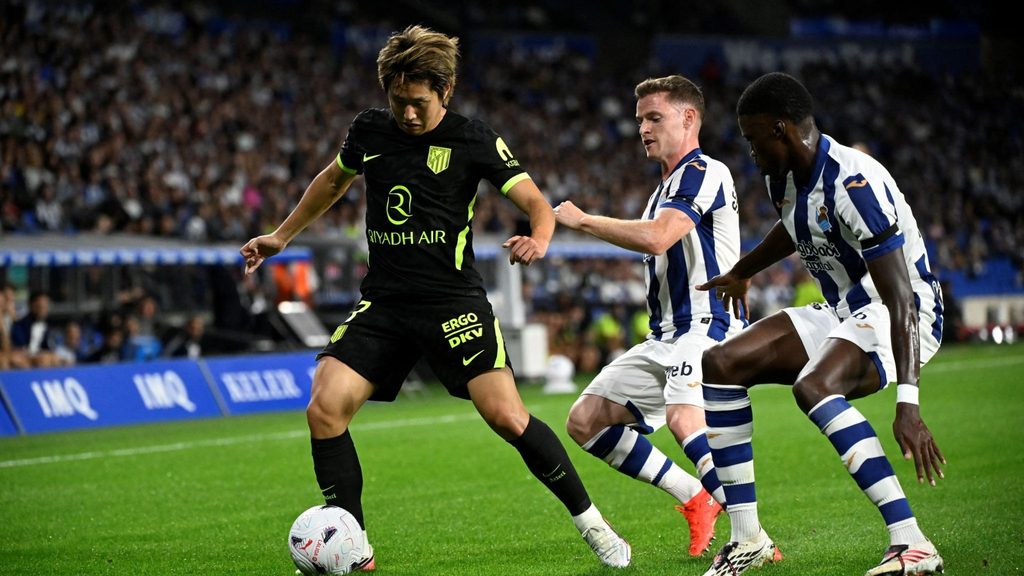 atletico-madrid-vs-real-sociedad-pambano-la-liga Mchezaji wa Atlético Madrid akiwa na mpira miguuni huku akidhibitiwa kwa karibu na mabeki wawili wa Real Sociedad.