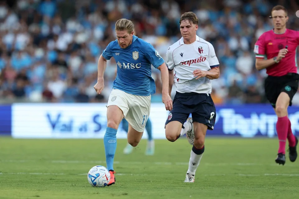Kiungo wa Napoli Kevin De Bruyne akirun na mpira uwanjani huku akidhibitiwa na mchezaji wa Bologna kwenye mechi ya Serie A