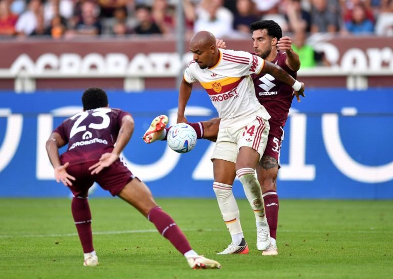 Mapambano ya Mpira Kati ya Torino na AS Roma kwenye Serie A Mchezaji wa AS Roma akipambana na wachezaji wa Torino uwanjani wakati wa mchezo