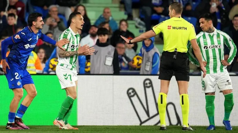 mzozo-uwanjani-mwamuzi-real-betis-vs-getafe Mwamuzi akitenganisha wachezaji wa Real Betis na Getafe wakati wa mzozo uwanjani.