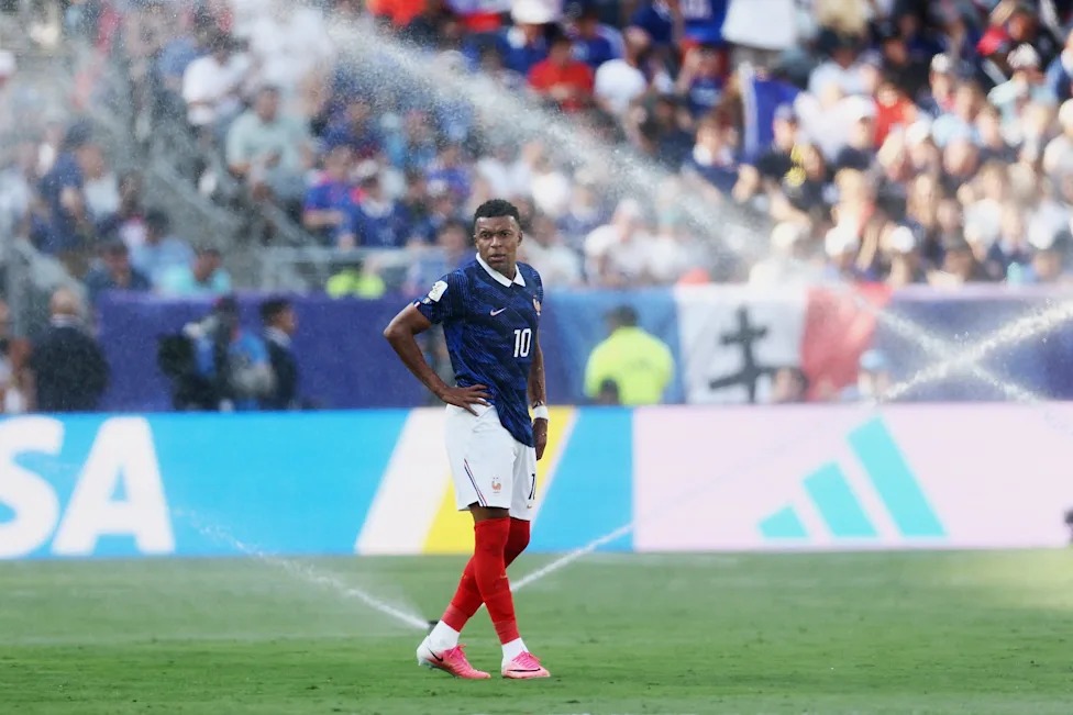 Kylian Mbappé Uwanjani Akiwa na Timu ya Taifa ya Ufaransa Kylian Mbappé akiwa amesimama uwanjani wakati wa mechi ya kimataifa akitazama mabadiliko ya udhamini wake wa viatu