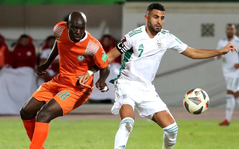 Kapteni na nyota wa timu ya taifa ya Algeria, Riyad Mahrez, akiwa anamiliki mpira huku akisukumana na mchezaji mpinzani