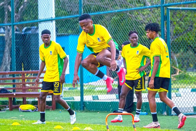 Mchezaji wa timu ya taifa ya Tanzania Taifa Stars akiruka kiunzi wakati wa mazoezi huku wenzake wakiangalia kwa karibu uwanjani