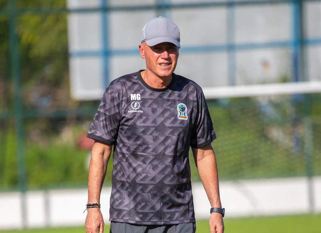 Kocha Mkuu wa Timu ya Taifa ya Tanzania Taifa Stars Uwanjani Kocha wa Taifa Stars akiwa amesimama kwenye uwanja wa mazoezi akiwa amevaa kofia na nguvu za mazoezi