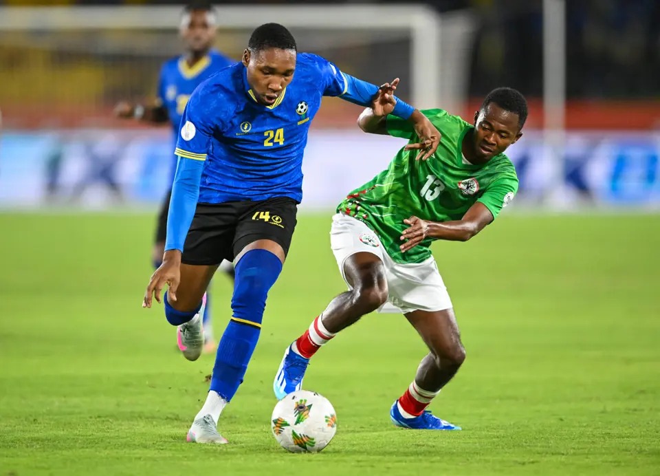 Mchezaji wa Tanzania akiwa na mpira miguuni huku akikabiliwa na mchezaji wa Madagascar katika mchezo wa mtoano.