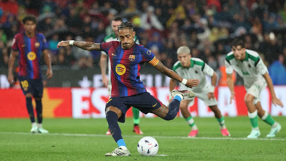Nahodha wa FC Barcelona Raphinha akipiga shuti kali la mpira huku wachezaji wa Racing Santander wakimfuatilia.