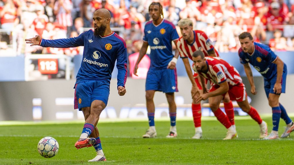 Mchezaji Bryan Mbeumo wa Manchester United akipiga mpira kwa mguu wa kushoto wakati wa pigo la adhabu huku wachezaji wa Atlético Madrid wakitazama.
