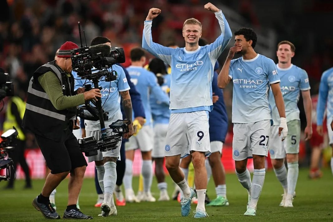 Erling Haaland akiwa ameweka mikono juu kwa furaha na kutabasamu baada ya filimbi ya mwisho kwenye mchezo dhidi ya Liverpool.