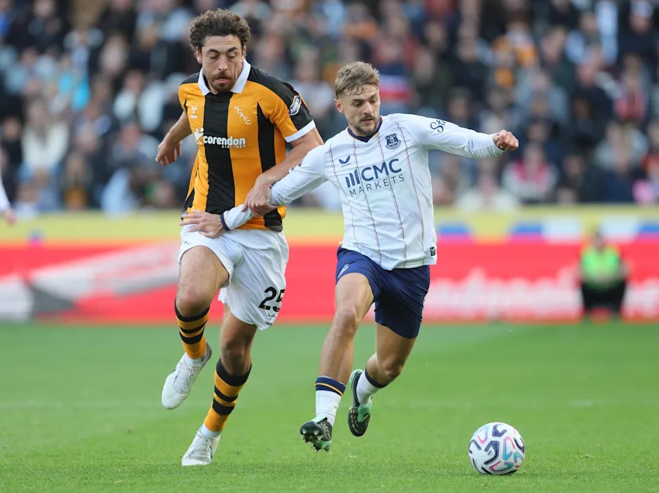 Mchezaji wa Everton akipambana na beki wa Hull City aliyevaa jezi ya meusi na ya njano kuwania mpira uwanjani.