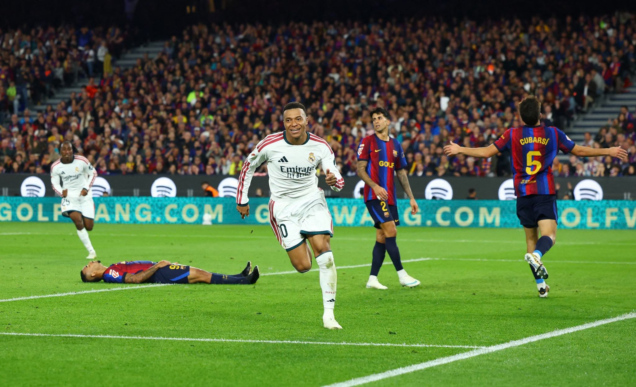 Kylian Mbappé akishangilia kwa furaha uwanjani huku wachezaji wenzake wakimfuata na mabeki wa Barcelona wakiwa wamekata tamaa.