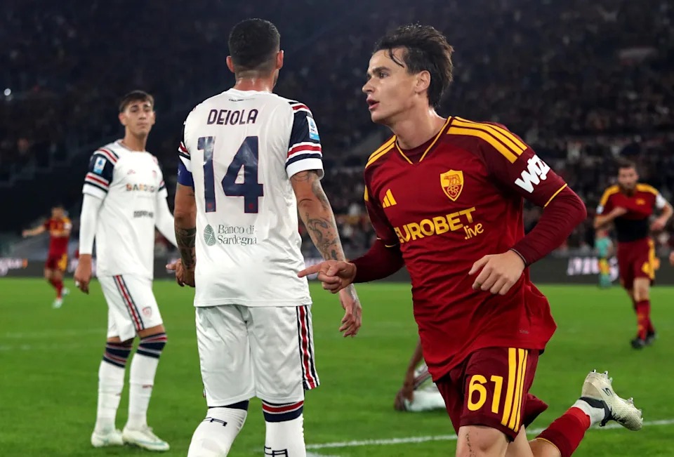 Mchezaji wa Roma aliyevaa jezi namba 61 akishangilia uwanjani huku mchezaji wa Cagliari akipita kwa mbali.