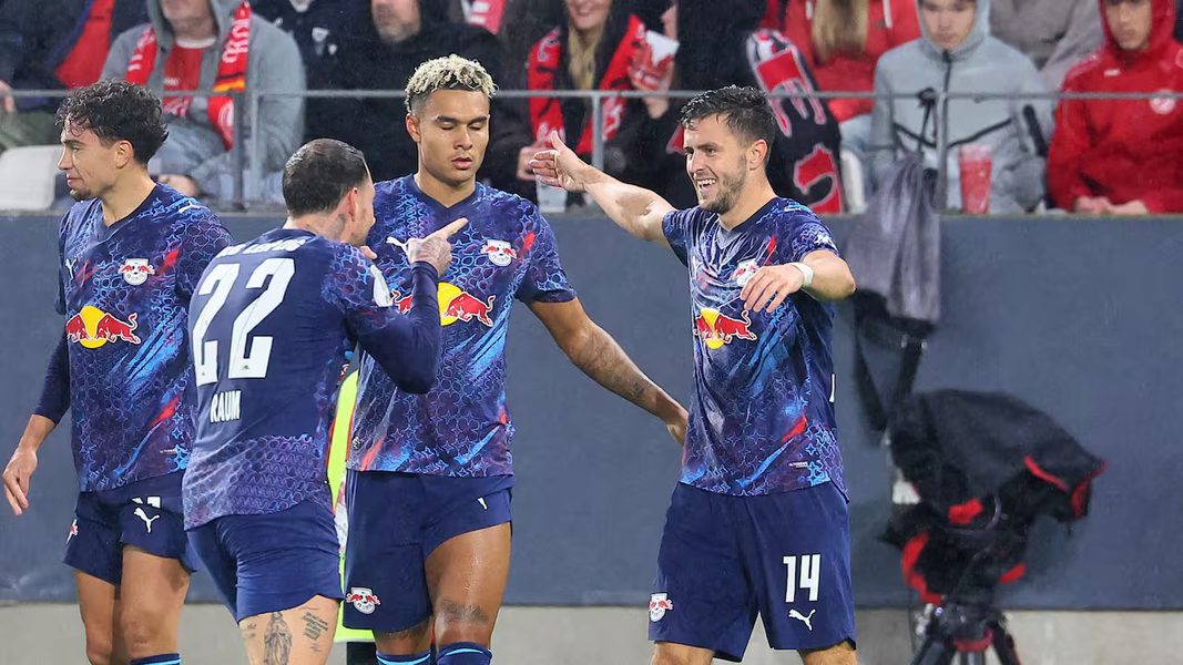 Wachezaji wa RB Leipzig waliovaa jezi za bluu wakipongezana uwanjani baada ya kupata ushindi ugenini.