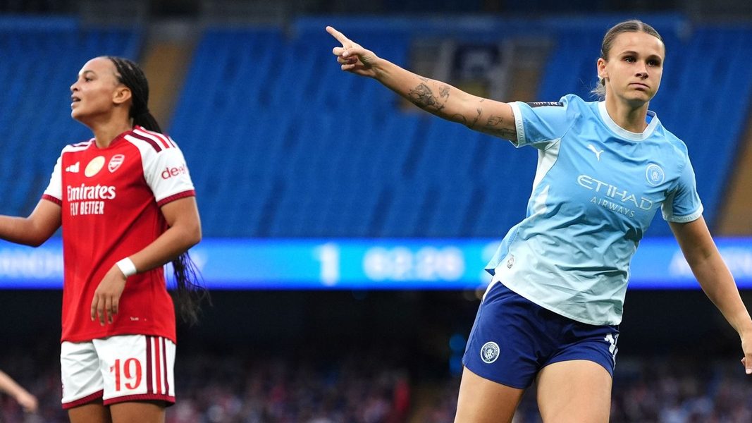 Wachezaji wa timu ya wanawake ya Manchester City waliovaa jezi za rangi ya bluu wakikumbatiana kwa furaha kubwa uwanjani