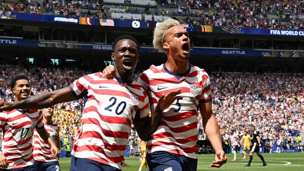 USA football players celebrate a goal during a FIFA World Cup match in front of cheering fans
