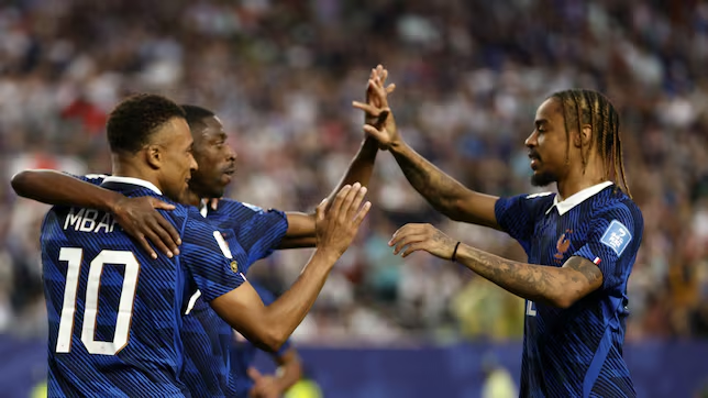 France captain celebrates with raised arms after scoring a goal.