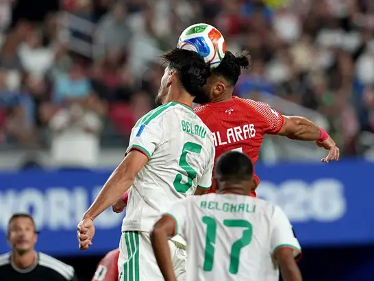 Saudi Arabia player heads the ball during an international match.