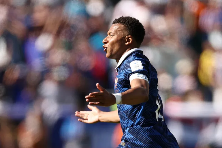 Kylian Mbappé is running in the playground after shooting the ball.