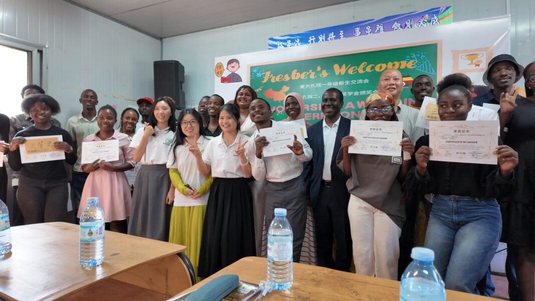 Part of the students who received Scholarships pause with their teachers during the event at Makerere University